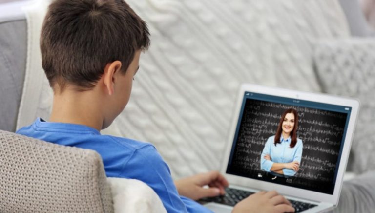 picture of a boy watching a teacher on a laptop